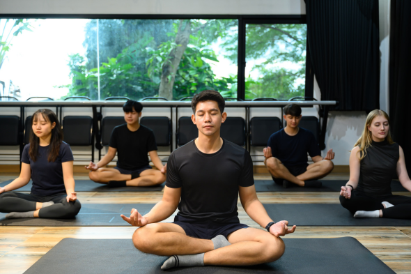 Employees practicing group mindfulness meditation during a workplace mental health and resilience training session.