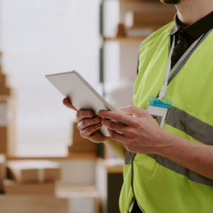 Medical logistics specialist inspecting device shipment inventory with a digital tablet in a distribution warehouse